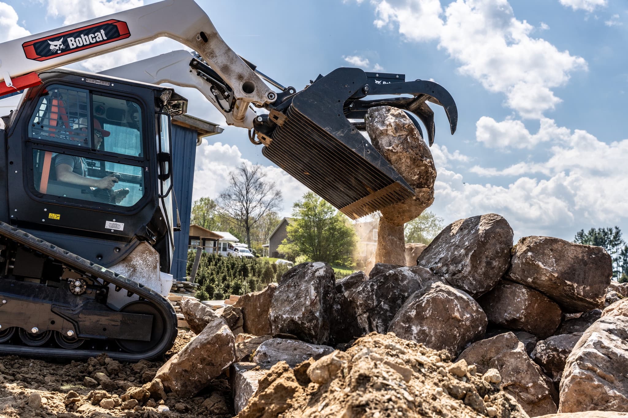 Bobcat compact track loader moving boulders